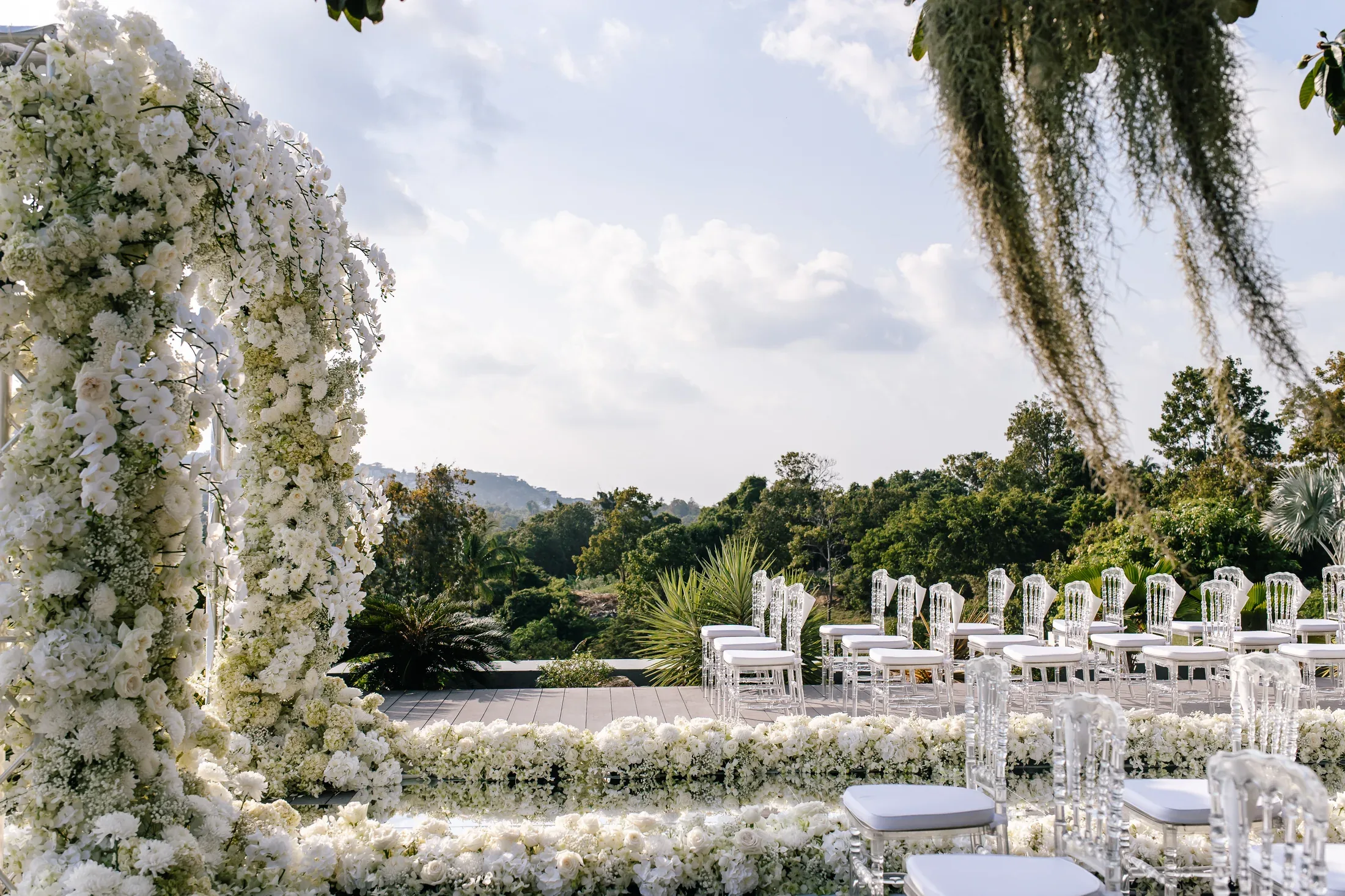 An ivory floral ceremony overlooking tropical hills