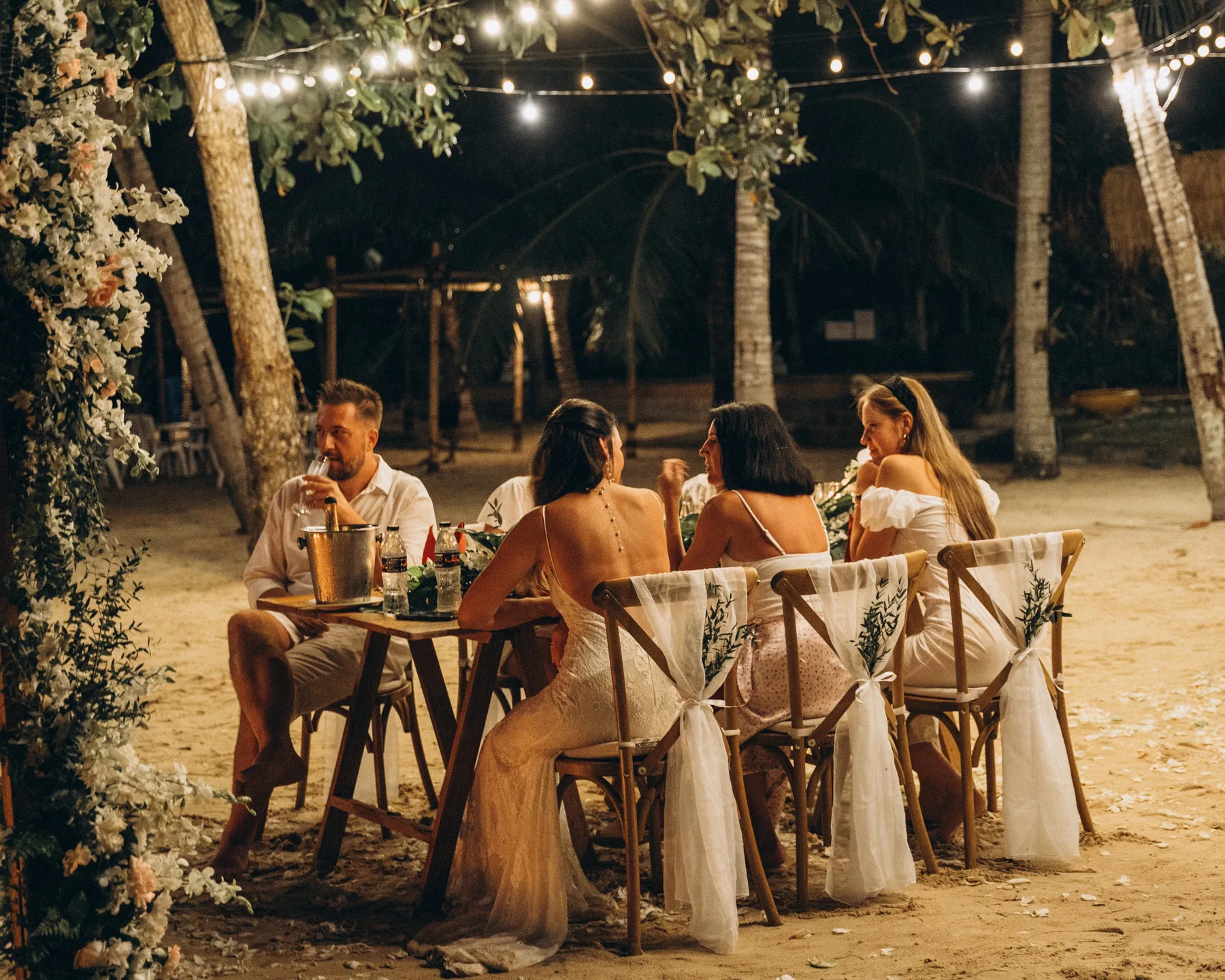 An intimate candlelit dinner beneath trees by the sea