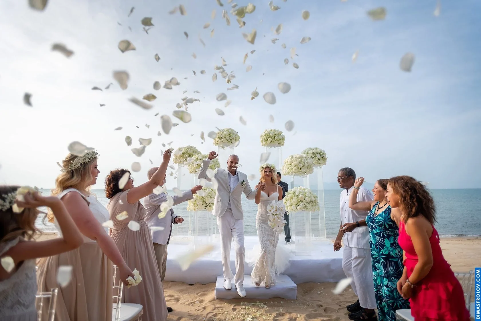 Newlyweds celebrating with guests after their beachfront wedding ceremony in Koh Samui